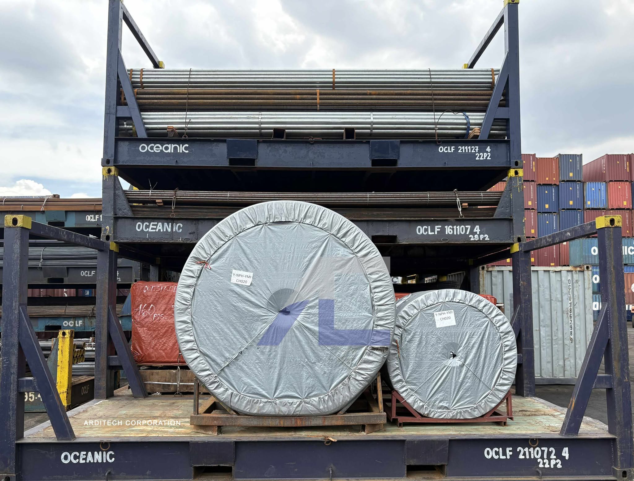 Steel pipes and rubber belt rolls loaded on Oceanic flat-rack containers at port for Arditech import